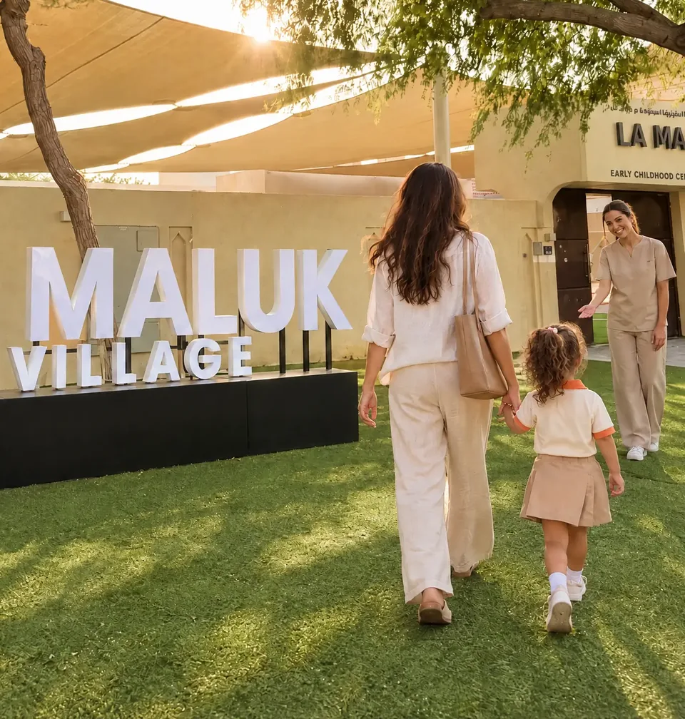 A mother and daughter welcomed by a teacher at the La Maluk Village entrance